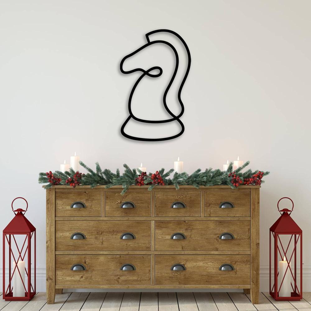 Black line art of a chess knight wall decor placed above a rustic wooden dresser adorned with Christmas-themed candles and lanterns.