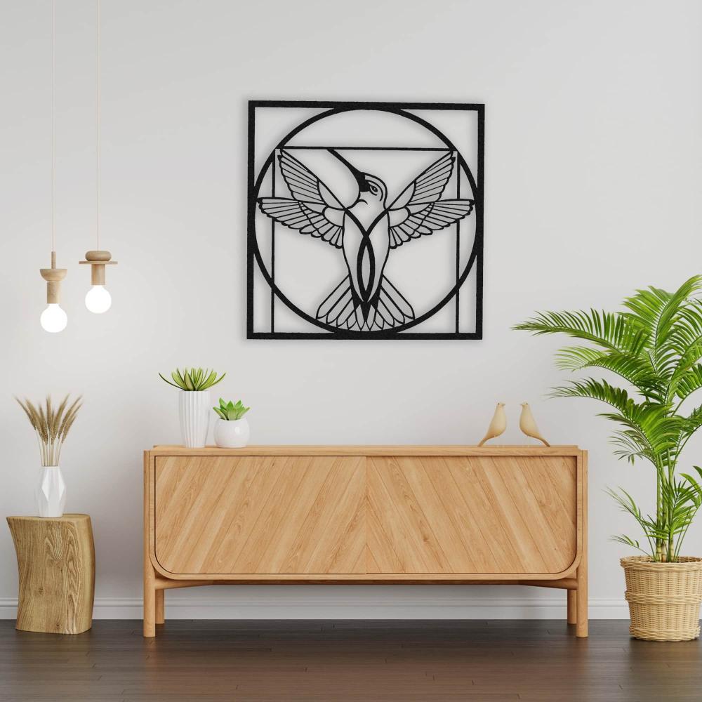 Stylish black metal wall art featuring a hummingbird with outstretched wings inside a circular geometric frame, mounted above a wooden cabinet with modern decor elements.