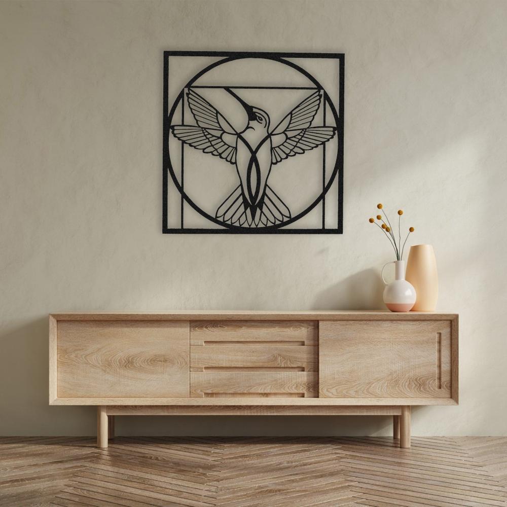 Black metal hummingbird wall art with a geometric circular design displayed above a modern wooden console table with minimalist decor.