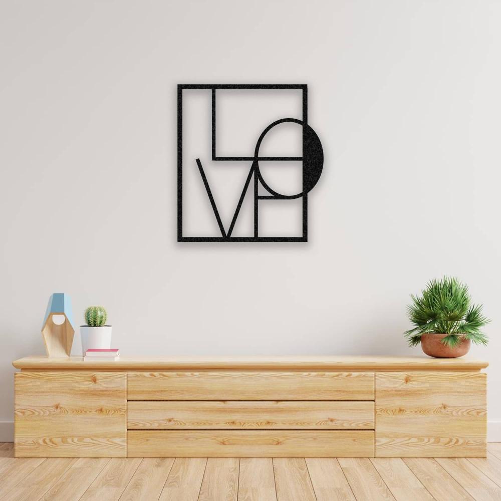 A minimalist living room with a wooden console table and decor items, featuring a black metal "LOVE" wall art in a geometric design mounted on a plain white wall.