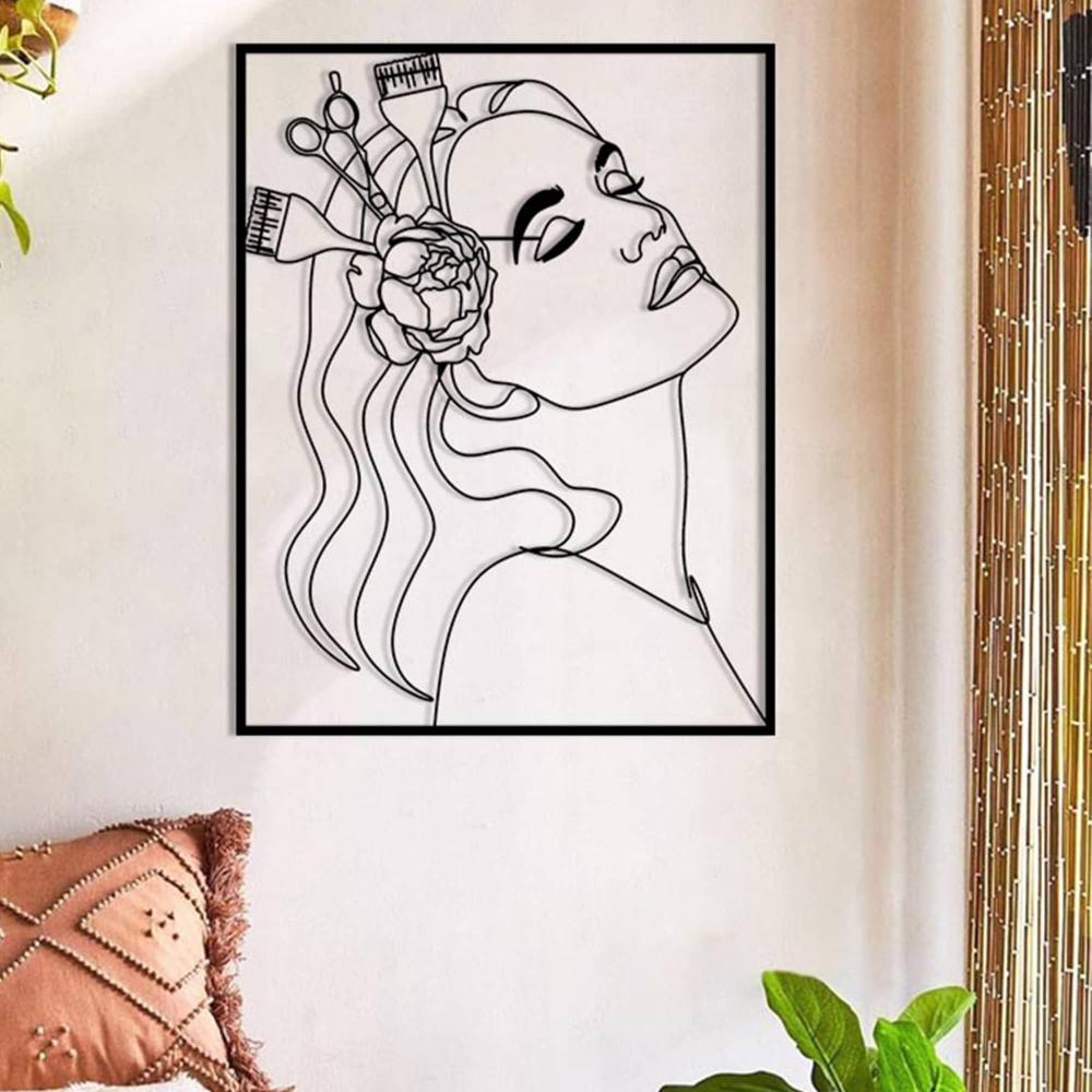 A stylish room featuring black metal wall art of a woman’s profile with a flower and hairdressing tools, mounted on a light wall with subtle natural decor.