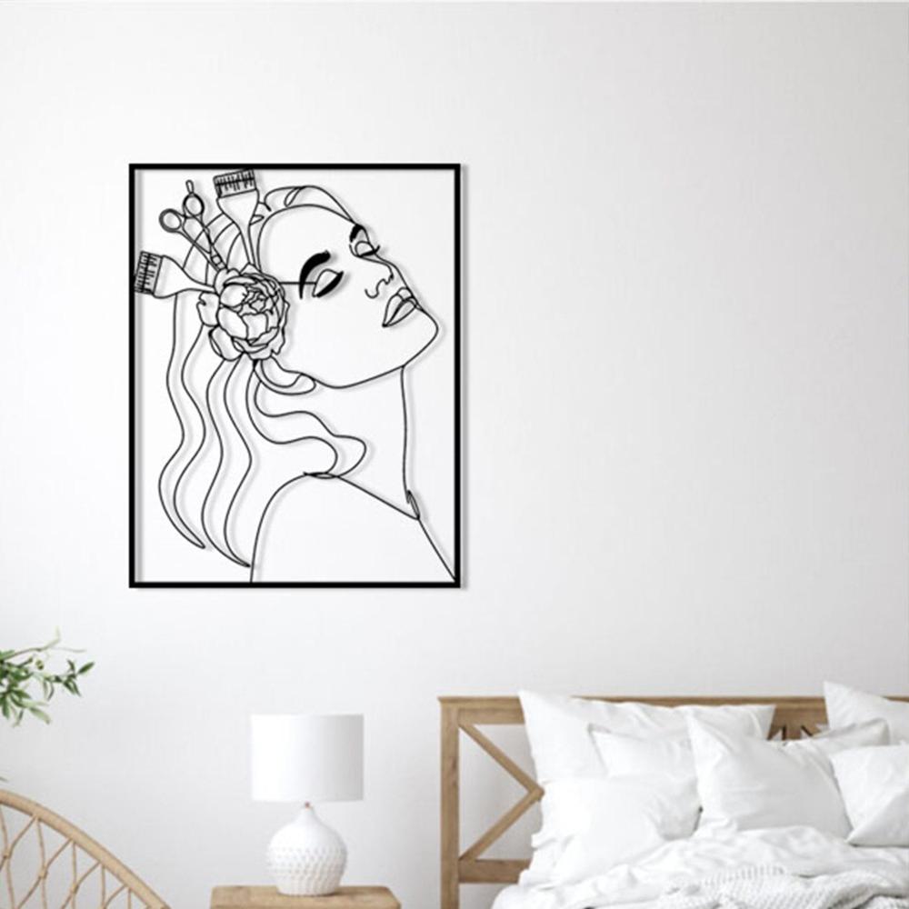 A serene bedroom with black metal wall art of a woman’s profile, showcasing a flower and hairdressing tools, mounted above a bed with white bedding.
