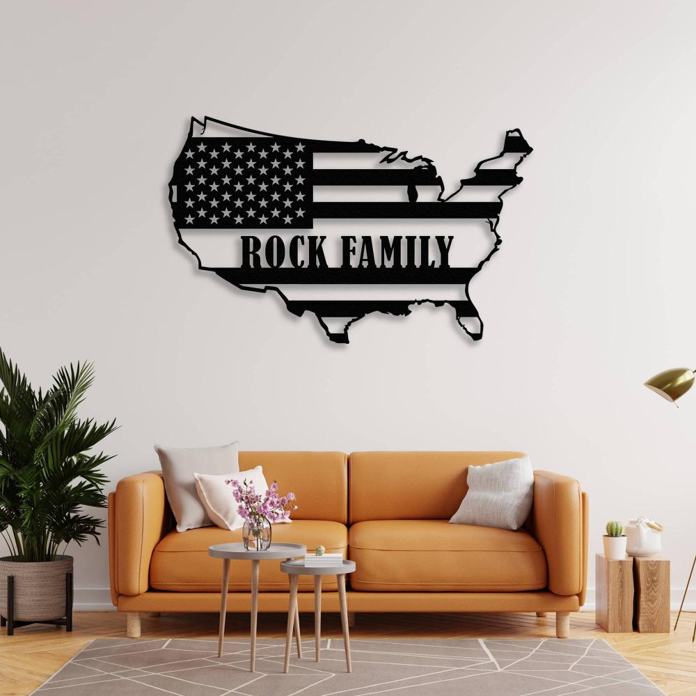 Black metal USA map wall art featuring "Rock Family" text, styled above an orange sofa with accent tables and plants for a bold living room design.