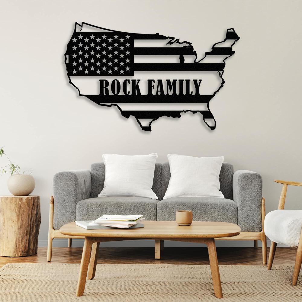 Black metal wall art of the USA map with the text "Rock Family," displayed above a gray sofa and wooden coffee table, creating a patriotic decor theme.