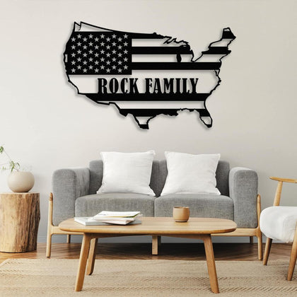 Black metal wall art of the USA map with the text "Rock Family," displayed above a gray sofa and wooden coffee table, creating a patriotic decor theme.