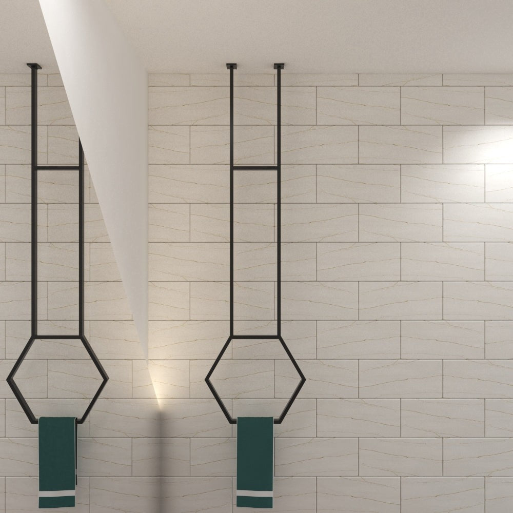 Two black hexagonal ceiling-mounted towel racks in a bright, minimalist bathroom, each holding a teal towel, complementing the modern design