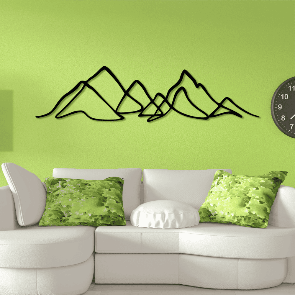 Minimalist black metal mountain wall art decor displayed on a bright green wall above a white sofa with green-patterned cushions.