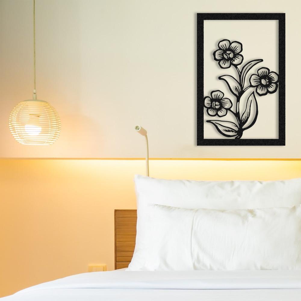 A modern interior with gray walls and a black metal floral wall art displayed above a gray sofa with blush-colored cushions.