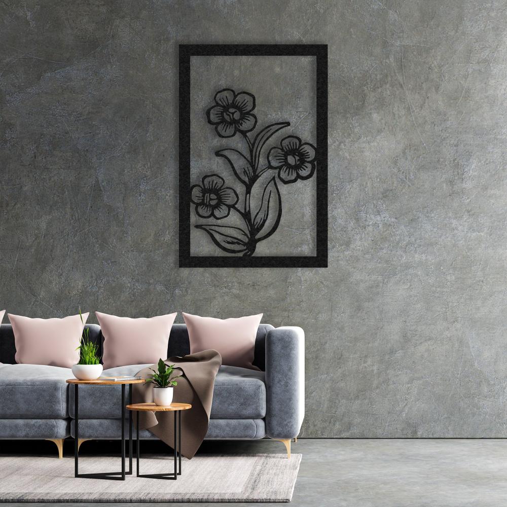 A modern interior with gray walls and a black metal floral wall art displayed above a gray sofa with blush-colored cushions.