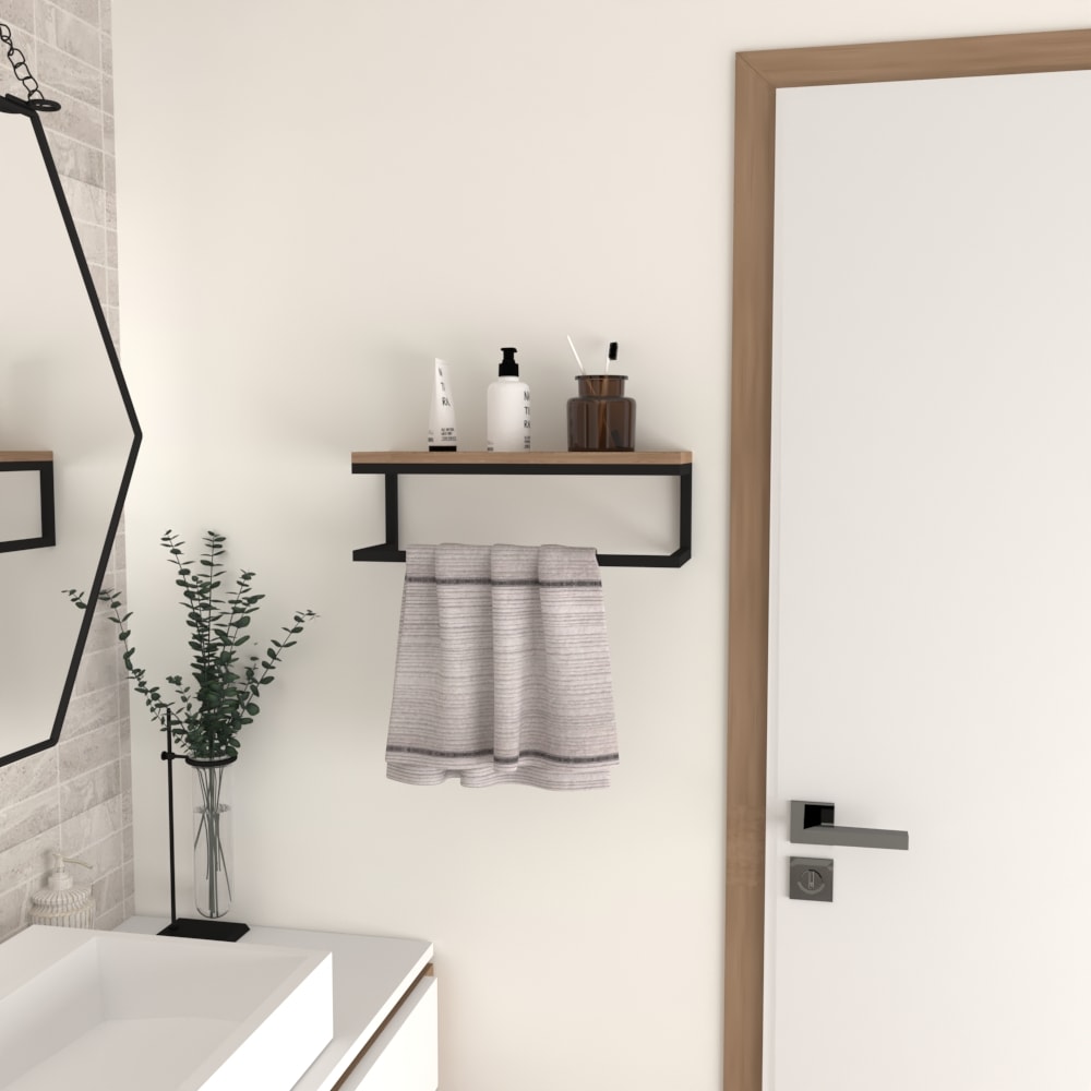 A modern towel holder installed next to a bathroom door, featuring a black metal frame, wooden shelf, and a towel hanging below. Decor items like plants and bottles complete the setup.