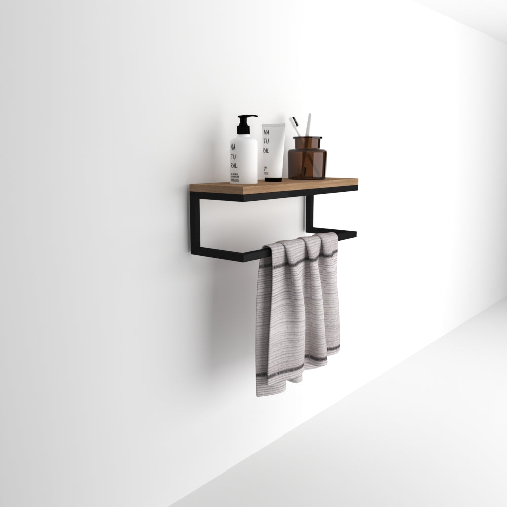 A wall-mounted towel holder doubling as a floating shelf with a natural wooden surface and black metal frame. The shelf holds bottles and a gray towel draped below.