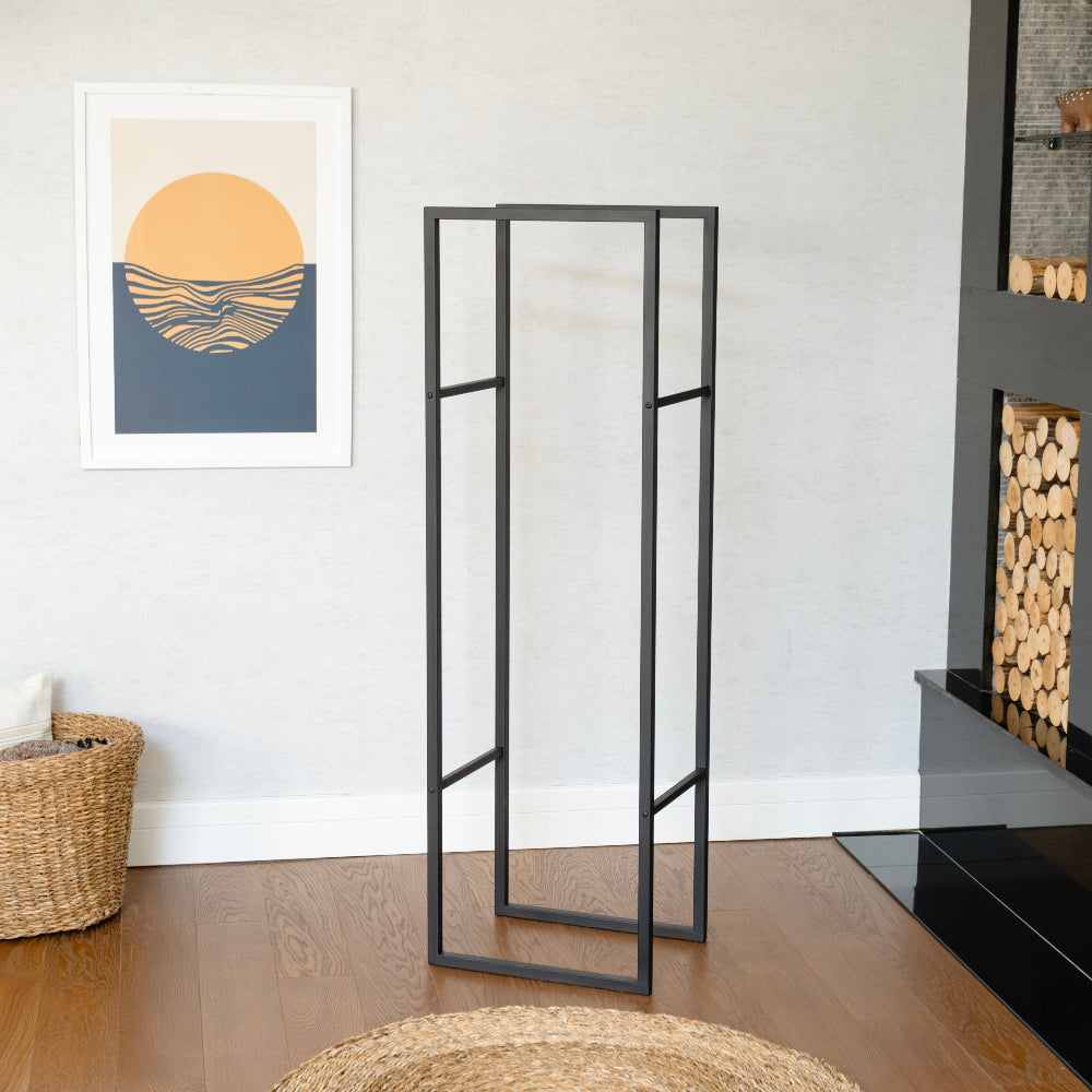 Black metal room divider in a modern living room with a wall art piece and fireplace. modern log holder for fireplace, minimalist firewood rack with shelf