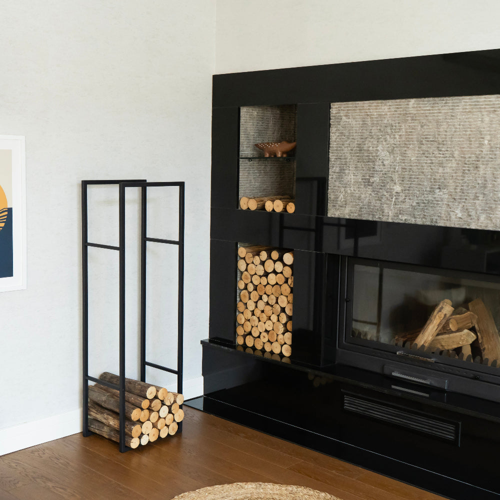 Modern black fireplace with decorative logs and a wooden stand in a living modern log holder for fireplace, minimalist firewood rack with shelfroom.
