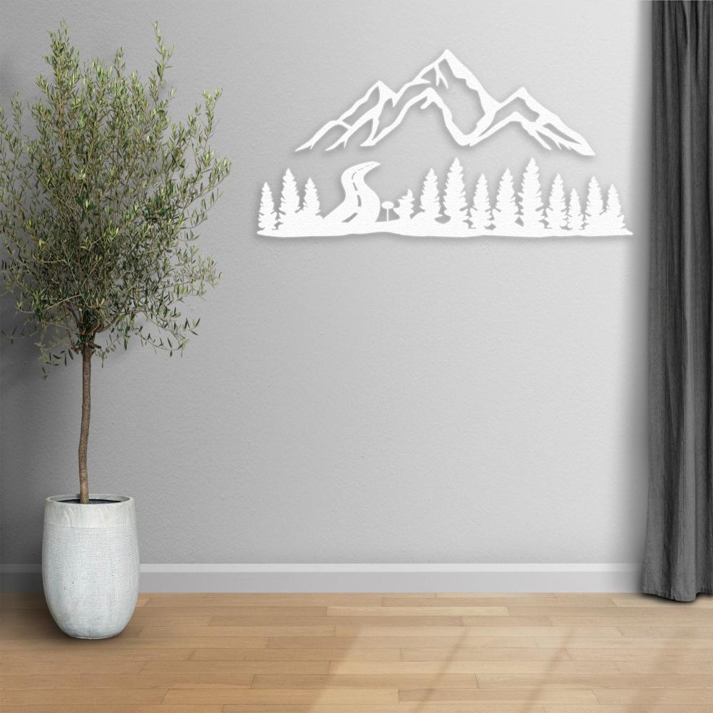 White mountain and forest-themed metal wall art decor mounted on a light gray wall, accompanied by a potted olive tree and a curtain, creating a serene and minimalistic interior atmosphere.