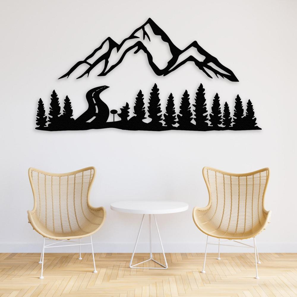 Black mountain and forest-themed metal wall art decor mounted on a white wall, paired with two woven rattan chairs and a small round white table, creating a modern and cozy interior setup.