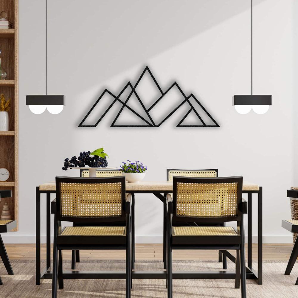 Black geometric mountain metal wall art displayed above a dining table with wooden chairs, modern pendant lights, and natural decor in a cozy dining area.