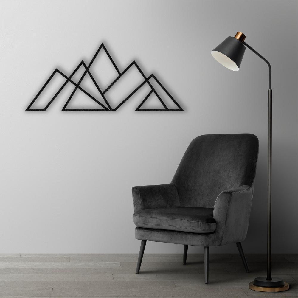 Sleek black geometric mountain metal wall art mounted on a light gray wall, styled with a modern black armchair and a tall floor lamp.