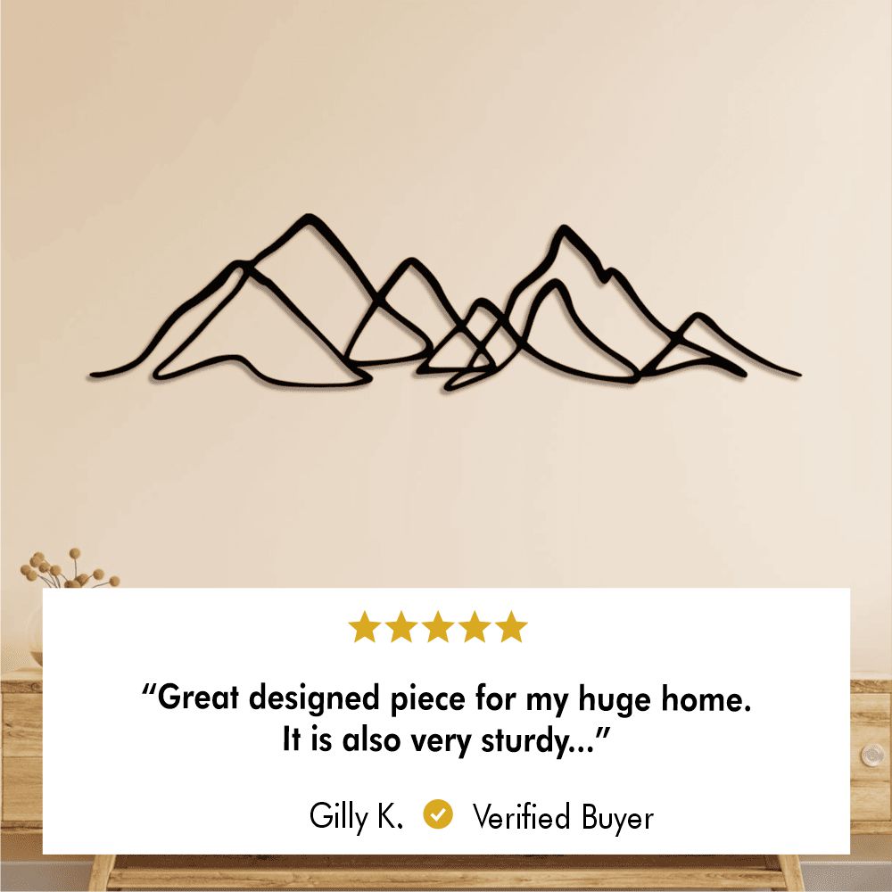 Metal mountain wall art hanging above a rustic wooden table, creating a serene and stylish home ambiance with a verified buyer review.