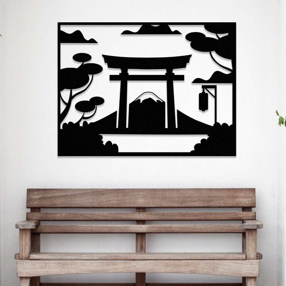A black metal wall art depicting a Japanese Torii gate with Mount Fuji in the background, placed above a wooden bench in a minimalist entryway.