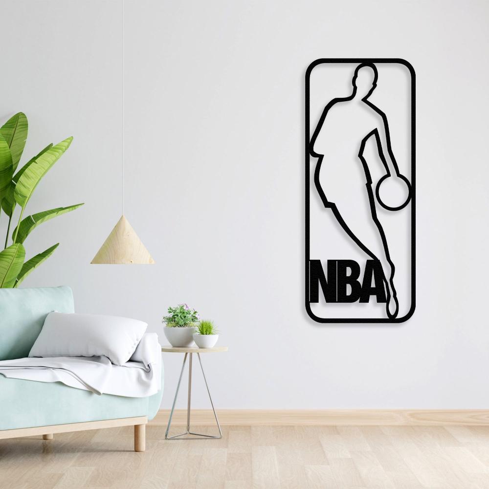 Black NBA-themed metal wall art featuring a basketball player silhouette, mounted on a white wall, beside a light green sofa with white cushions, a triangular wooden pendant lamp, and a small table with potted plants.