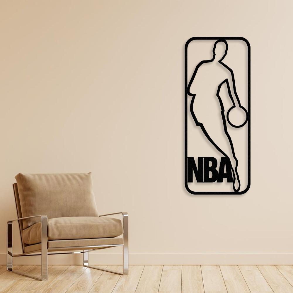 Black NBA-themed metal wall art showcasing a basketball player silhouette, mounted on a neutral beige wall, next to a modern beige armchair with a metal frame.