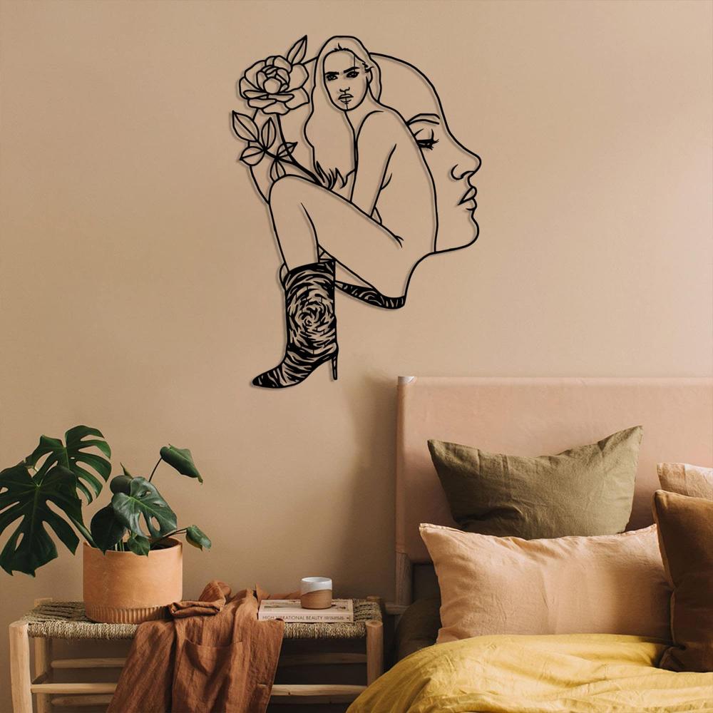 Earthy-toned bedroom with cozy green and beige accents featuring a modern metal wall art of a woman's face and floral elements on the wall.