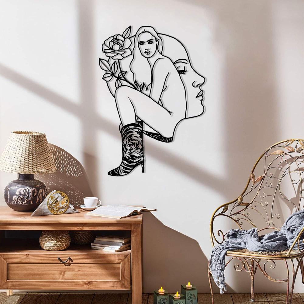 Bright corner with natural lighting, a stylish chair, and a modern metal wall art of a woman's form with a floral design.