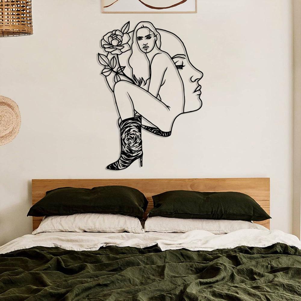 Minimalistic bedroom with neutral tones and a striking metal wall art of a woman’s profile and body adorned with a rose, mounted above the bed.