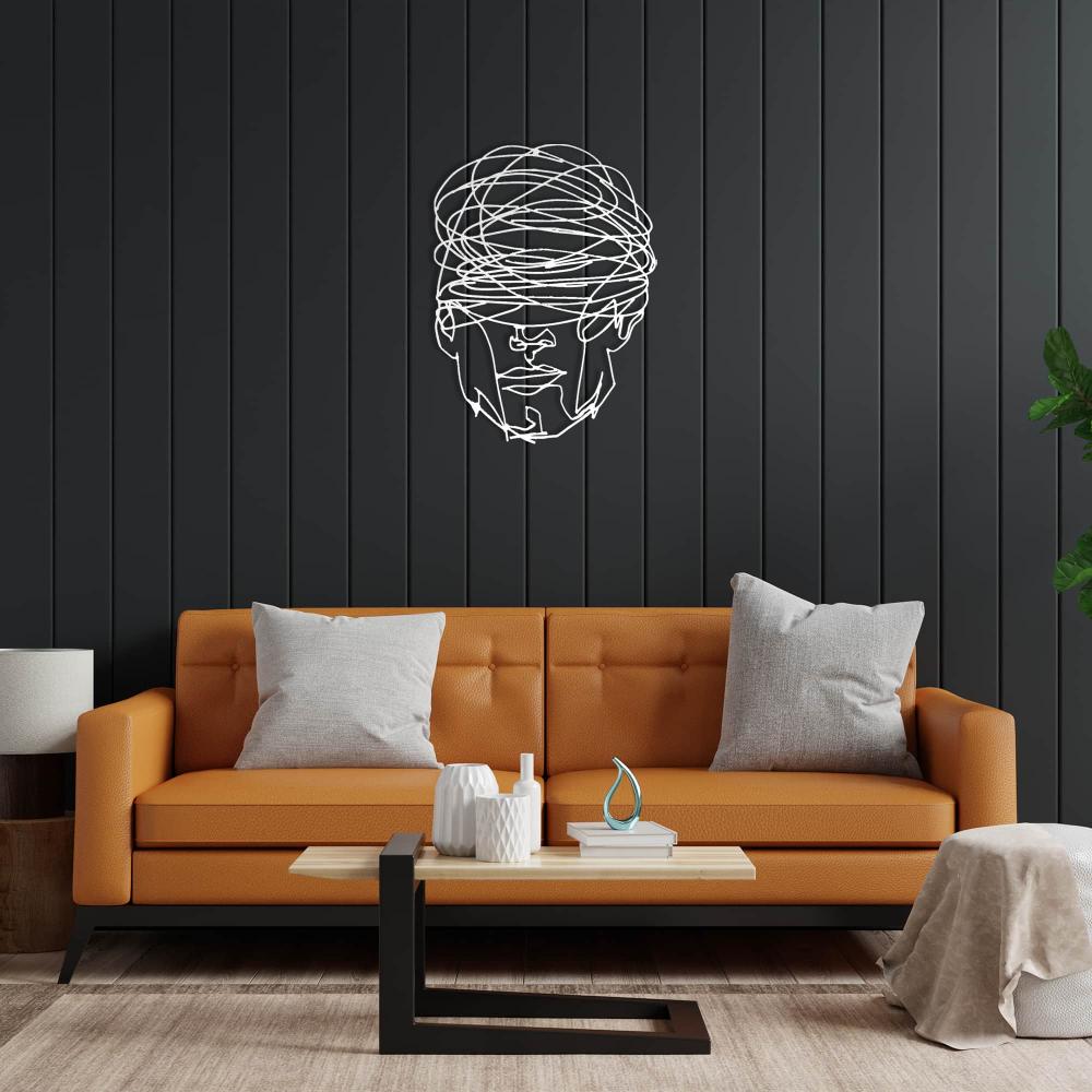 Modern living room featuring "Overthinking Man" white metal wall art mounted on a black paneled wall above an orange sofa, complemented by minimalist decor elements including a coffee table with ceramic vases and a beige ottoman.
