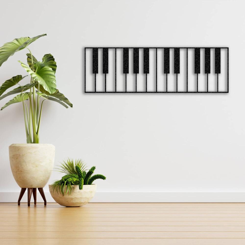 Piano keys-themed metal wall art in a black design, mounted on a plain white wall. The minimalist space features light wooden flooring and decorative potted plants in modern stone planters.