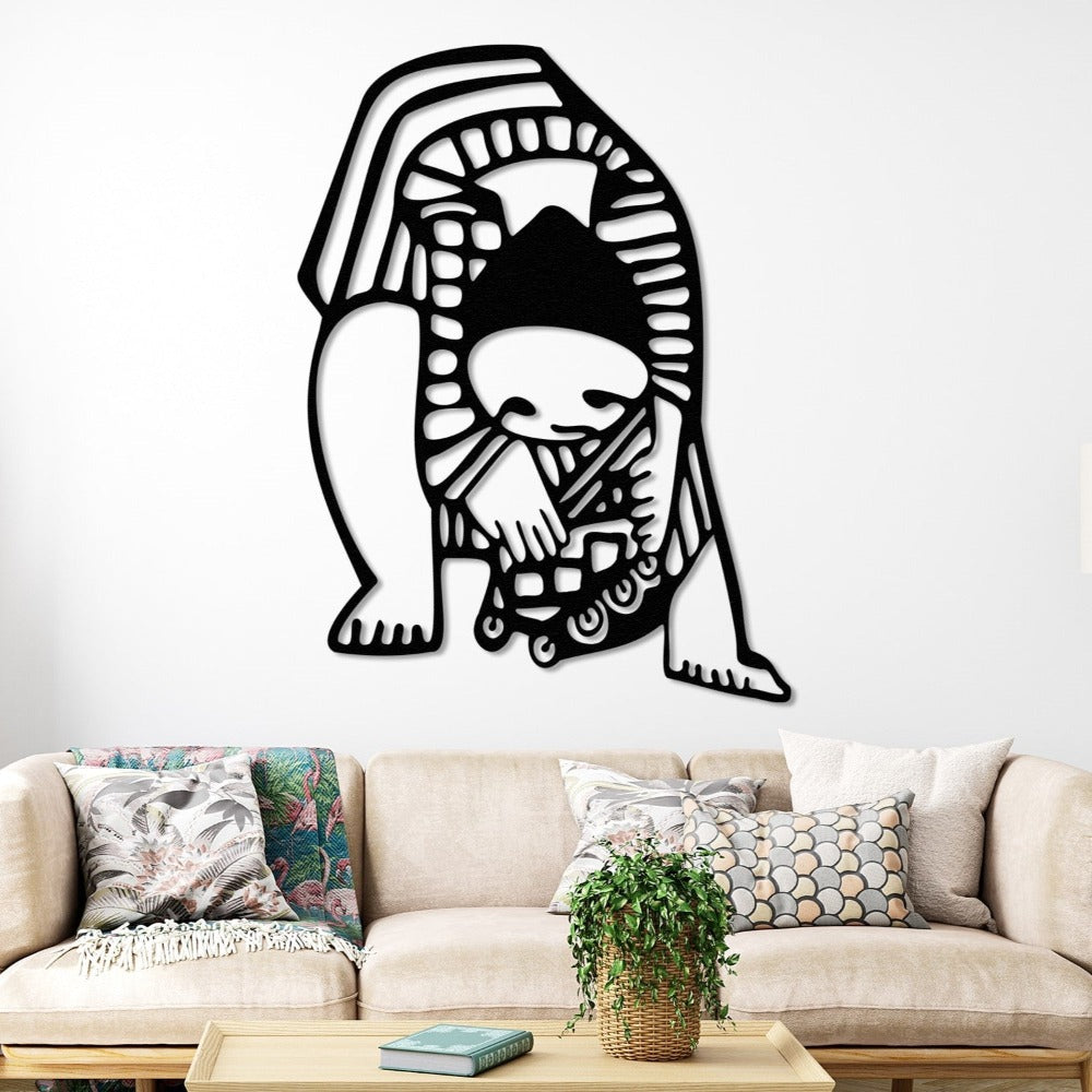 A creative black metal wall art of a child bending over with abstract patterns, hung on a white wall above a cozy sofa with colorful cushions.