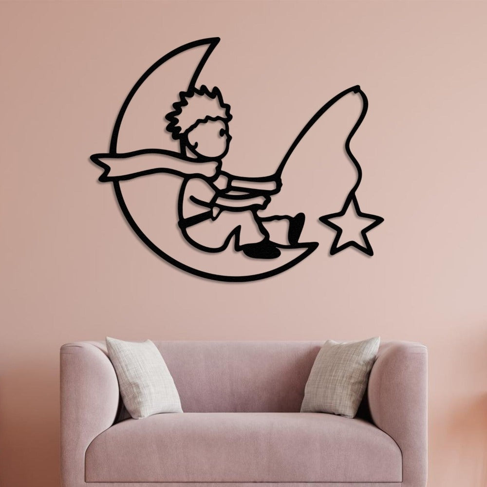 A modern black metal wall art piece of a child on a crescent moon, placed on a soft pink wall above a blush-colored sofa, blending elegance with a whimsical design.