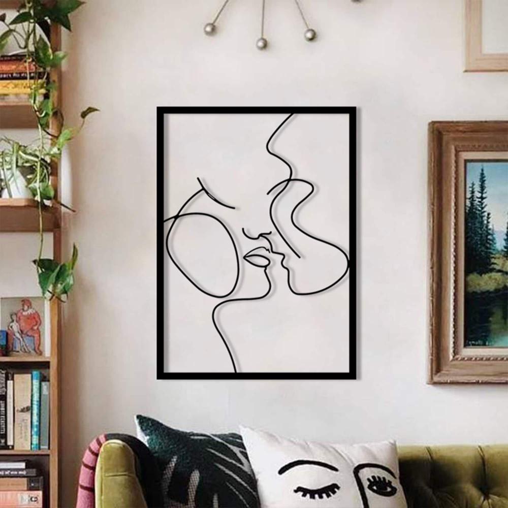A modern living room with a gallery-inspired setup, including an abstract "Relationship Goals" metal wall art depicting a romantic couple in minimalist lines, paired with a green velvet sofa and accent decor.