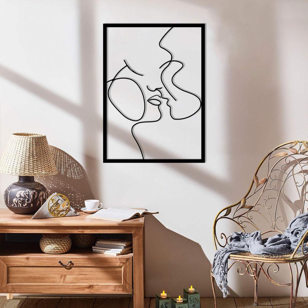 A cozy corner with a metal wall art of an abstract romantic couple titled "Relationship Goals," placed above a rustic wooden console with natural decor elements and candles.