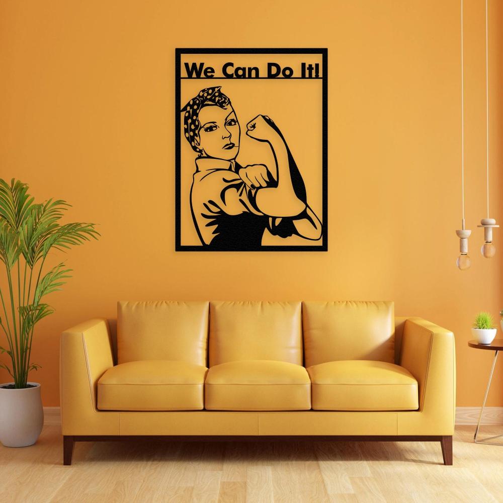 Black metal wall art of Rosie the Riveter with the "We Can Do It!" slogan, mounted on a bright yellow wall above a modern yellow couch, complemented by a plant and minimalist decor.