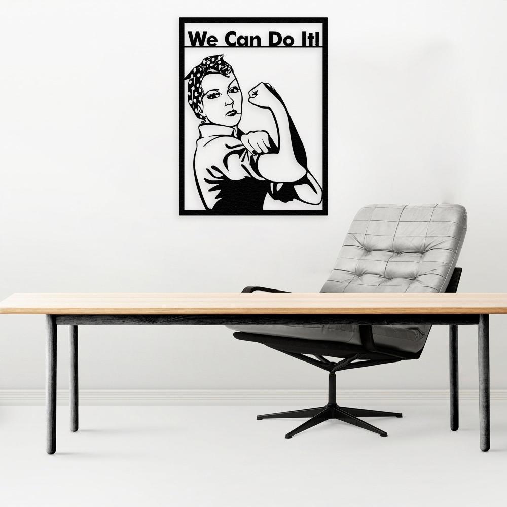 Sleek modern office space featuring a "We Can Do It!" Rosie the Riveter black metal wall art above a minimalist wooden desk paired with a gray upholstered swivel chair.
