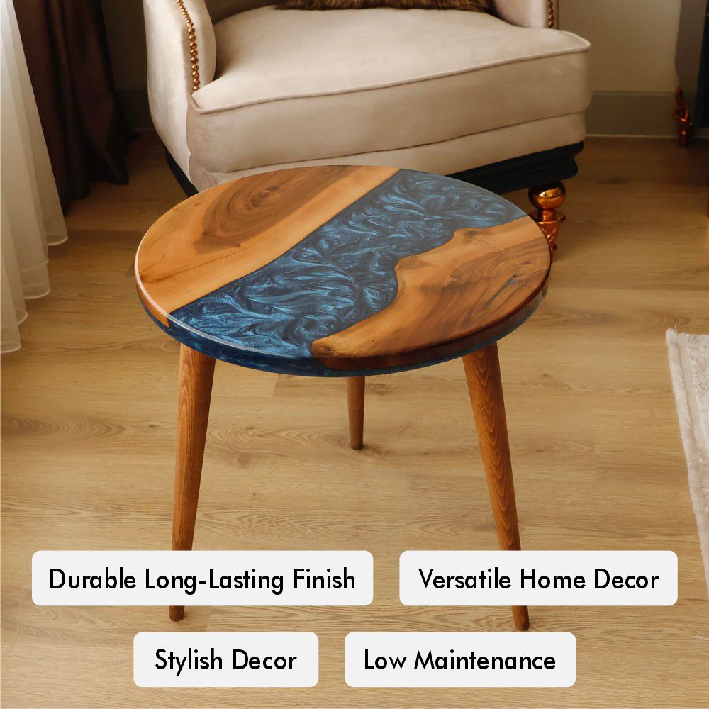 Round wooden table with blue resin accents in a living room featuring a beige armchair.
