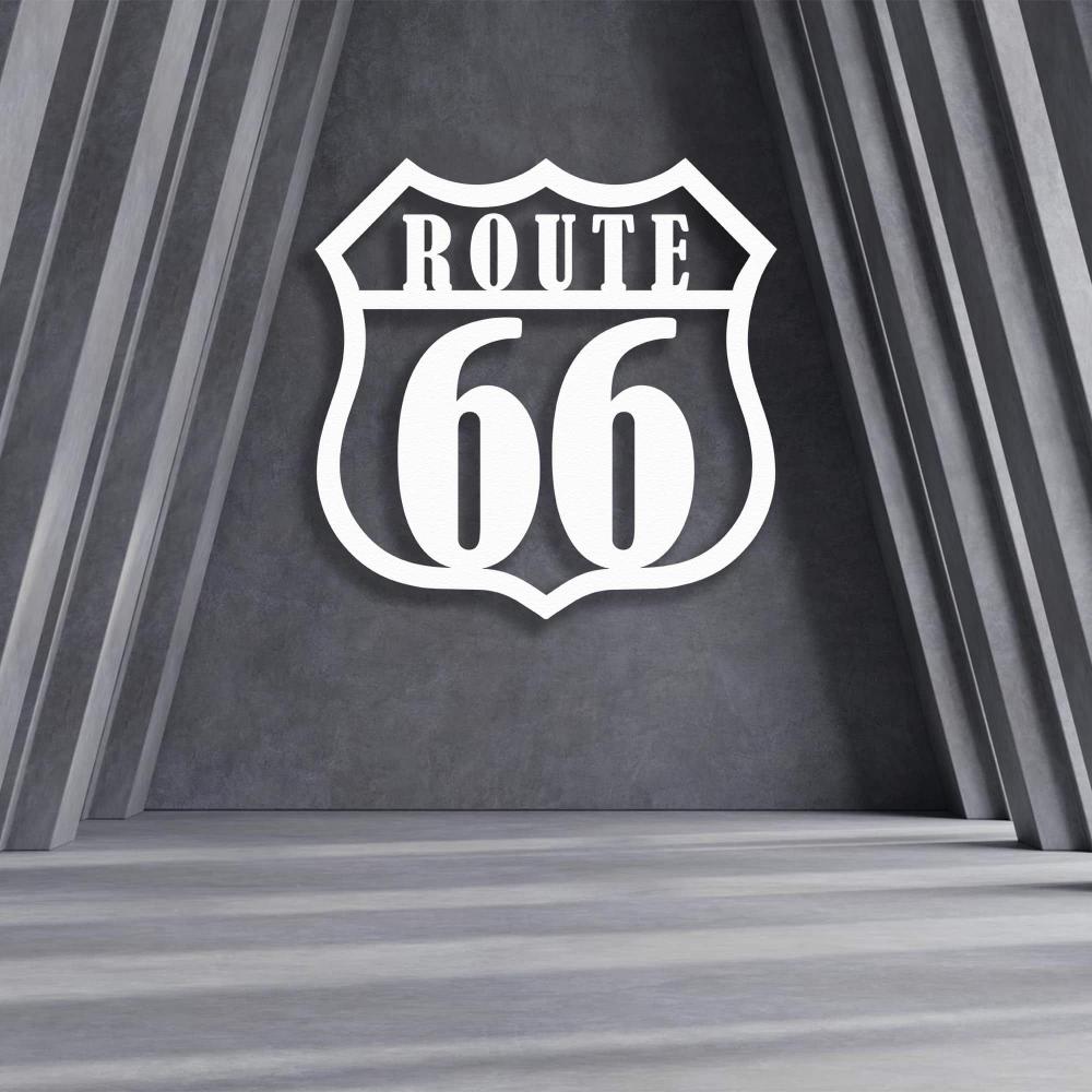 Route 66 metal wall art in white displayed against a modern gray concrete wall with geometric architectural elements, creating a bold and iconic statement piece.