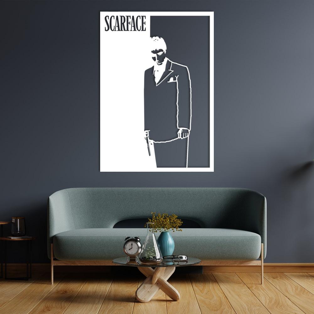 Scarface-themed wall art in black and white featuring a silhouette of a man in a suit holding a gun, displayed above a modern teal sofa with a minimalist wooden table and accessories in a contemporary living room setting.