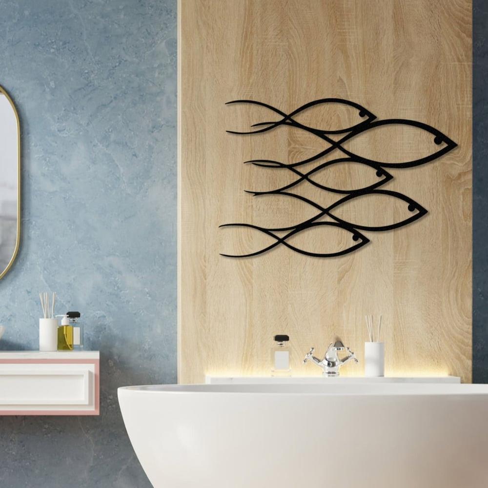 Black metal wall art featuring a school of fish design mounted on a natural wood panel backdrop in a modern bathroom, complemented by a freestanding white bathtub and a blue accent