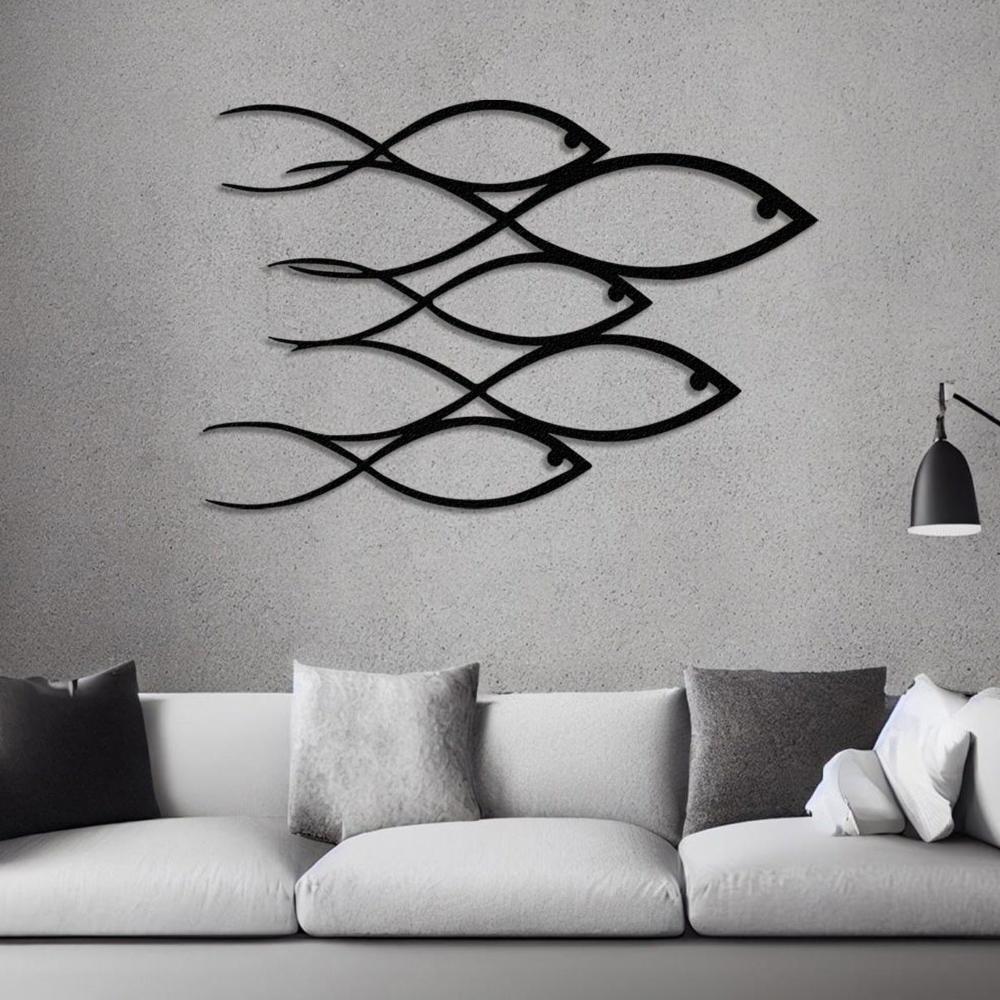 Modern "School of Fish" metal wall art in a sleek black finish, displayed on a minimalist gray wall above a white sofa with gray cushions.