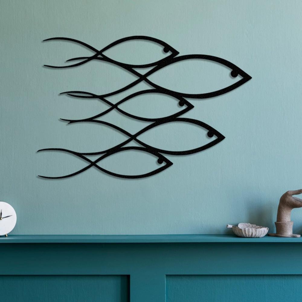 Contemporary black metal wall art featuring a school of fish design mounted on a pastel blue wall, placed above a teal shelf adorned with minimalist decor items.