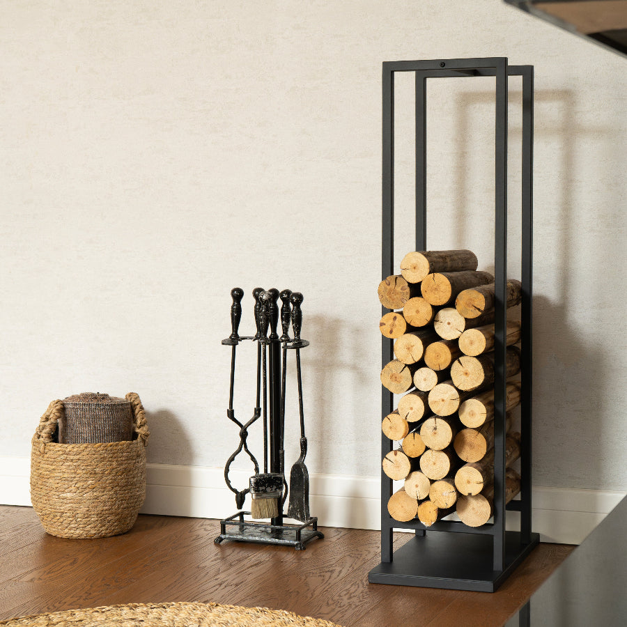 Firewood rack with logs, fireplace tools, and a basket on a wooden floor.