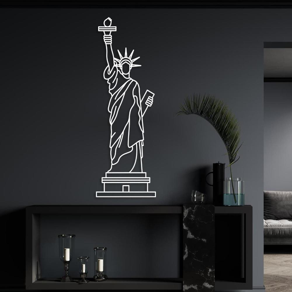 White line art of the Statue of Liberty metal wall decor displayed against a dark wall with decorative elements.