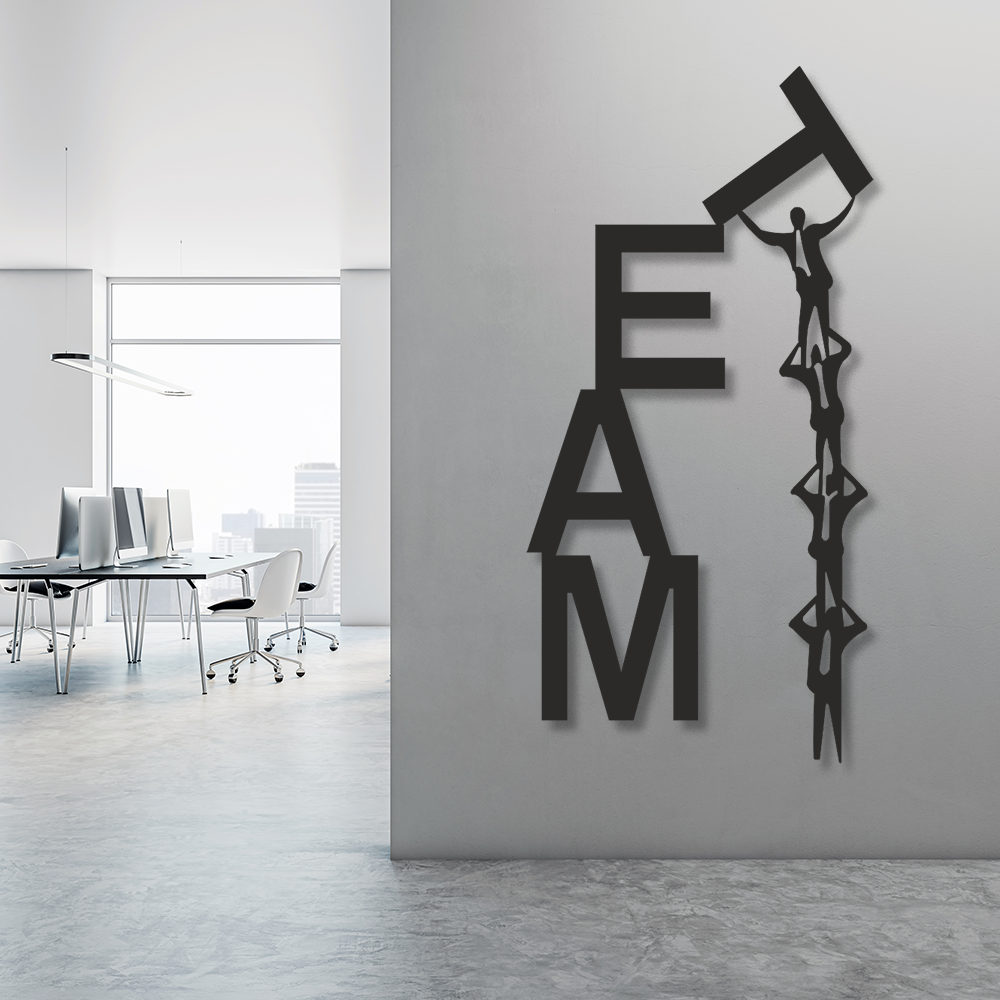 Decorative wall art with 'TEAM' letters and a person climbing over a chain on a gray wall.