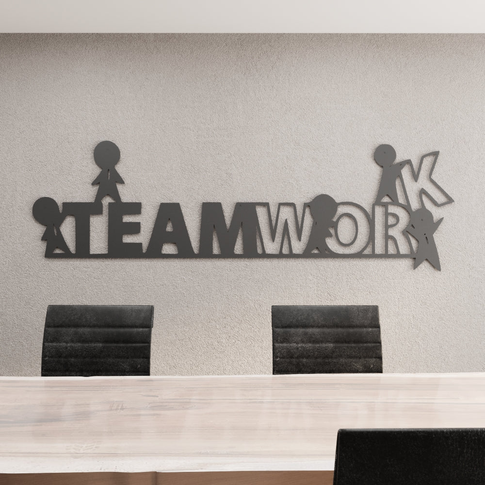 Decorative wall art with 'TEAMWORK' on a plain wall above a desk.