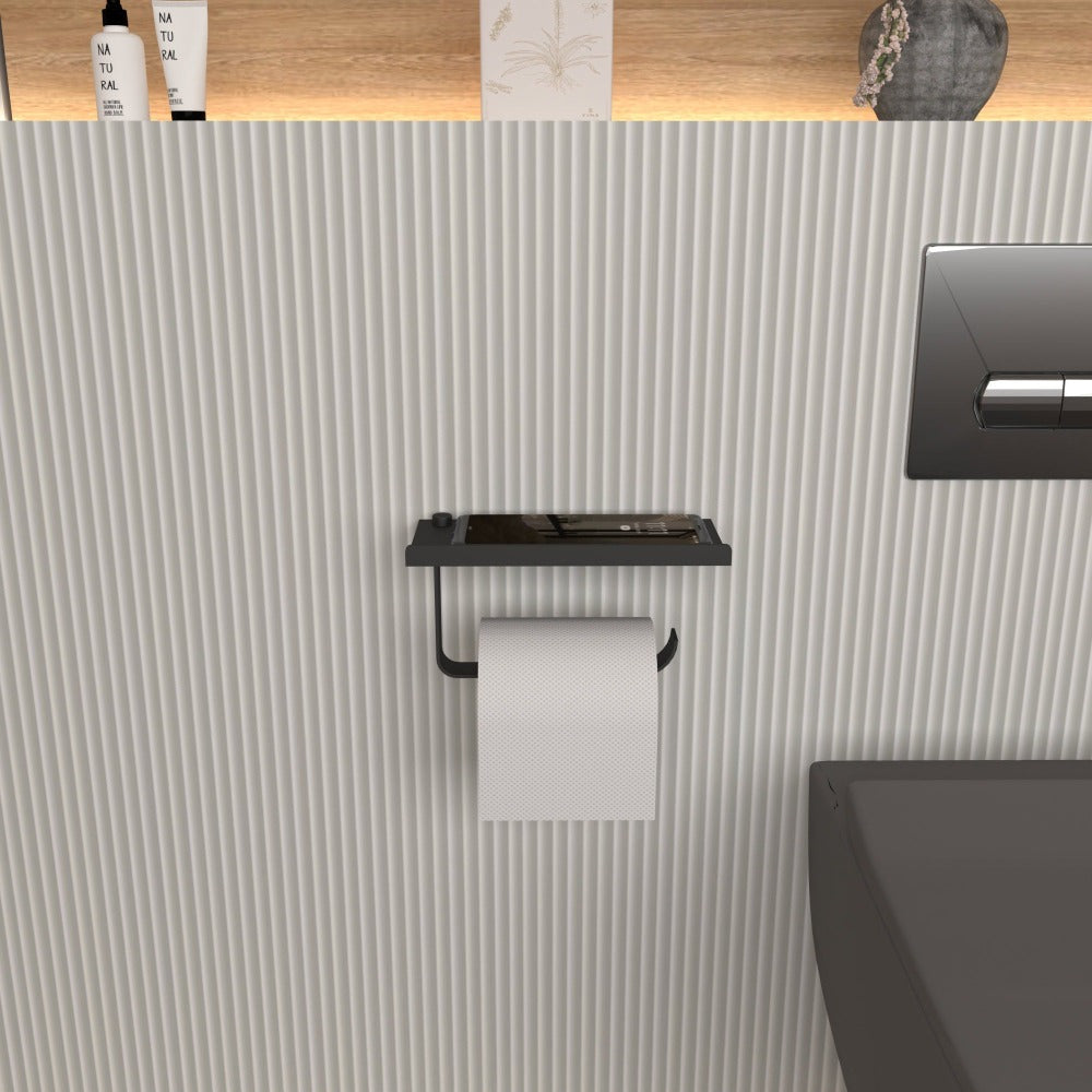 Black wall-mounted toilet paper holder with a smartphone on its shelf, shown in a minimalist bathroom setting