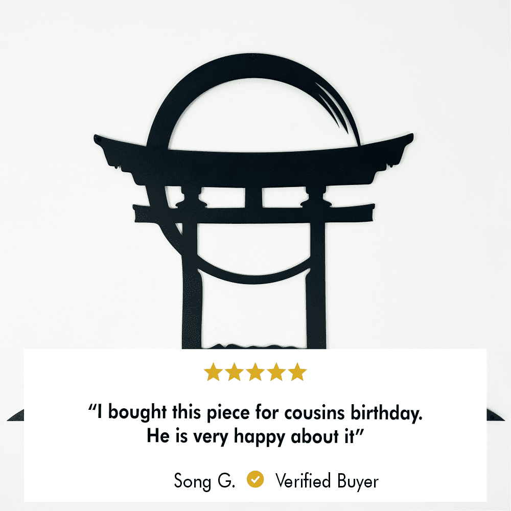 A close-up of the Torii gate metal wall art with a 5-star review text overlay stating, "I bought this piece for cousin's birthday. He is very happy about it."