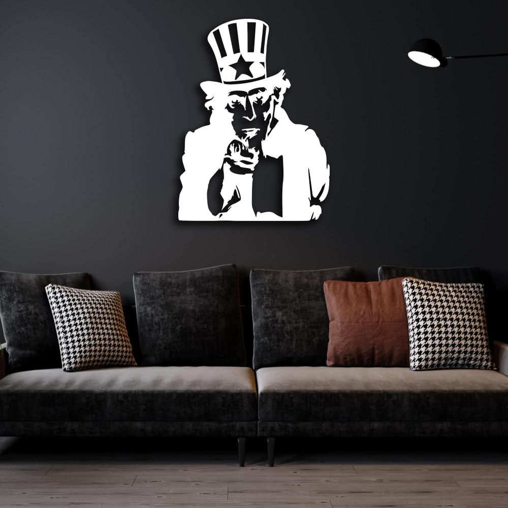White metal wall art of Uncle Sam mounted on a dark wall, creating a striking contrast in a stylish living room with a dark velvet sofa and patterned pillows.