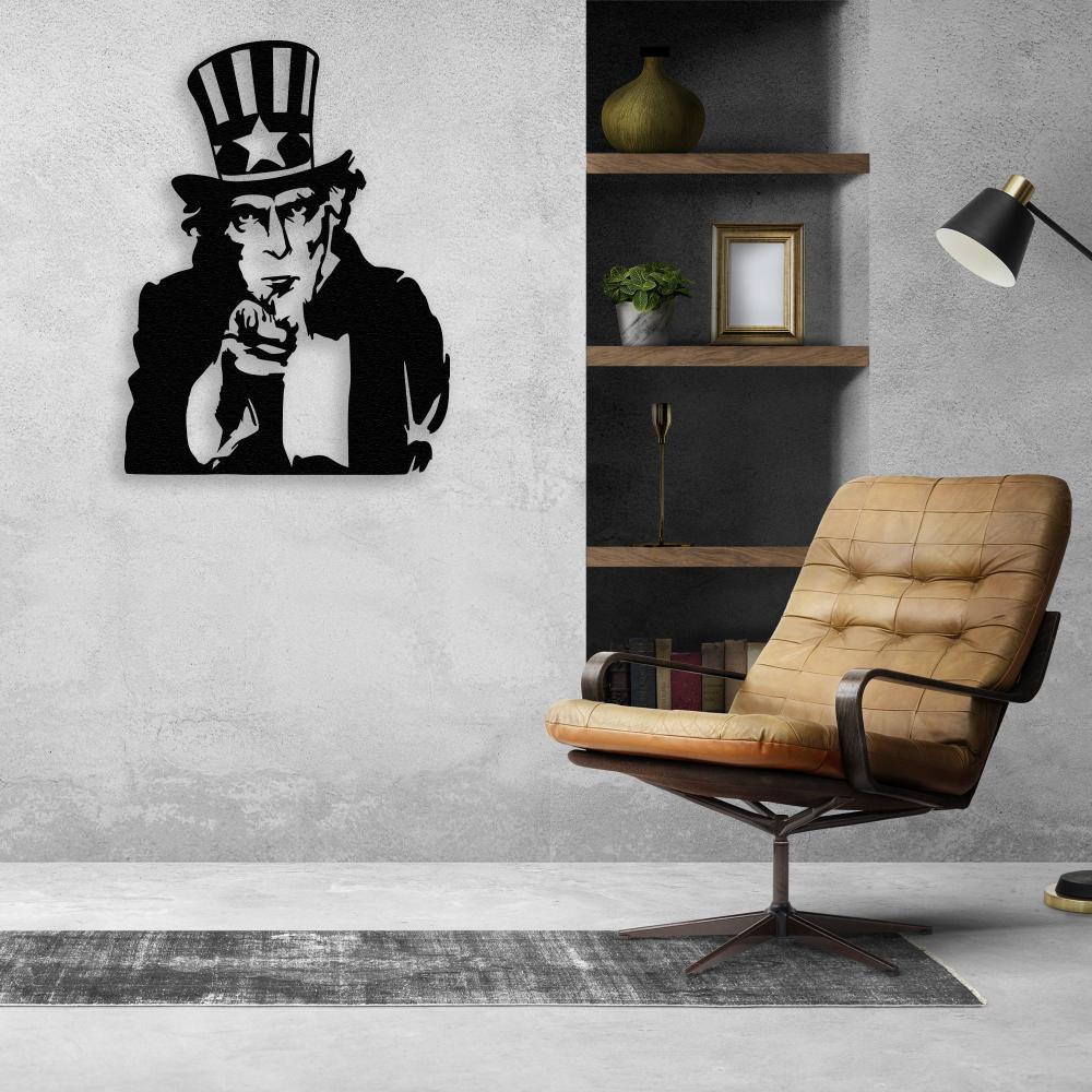 Black metal wall art of Uncle Sam displayed on a concrete wall in a modern industrial setting, complemented by a leather swivel chair and built-in wooden shelves.